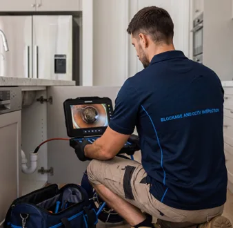 Plumber clearing a blocked toilet in a Breakfast Point bathroom